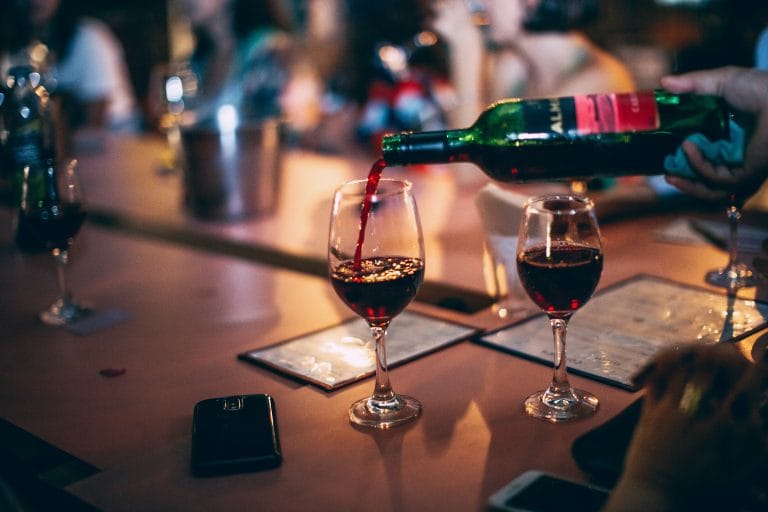 Rotwein wird in ein Weinglas gegossen.